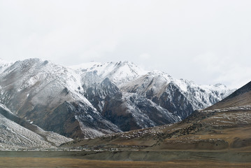 Snowy mountains in clouds in Tibet panorama view