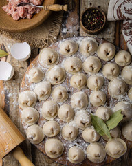 Dumplings with meat in process of cooking. Ingredients for cooking. Traditional russian and ukrainian food.