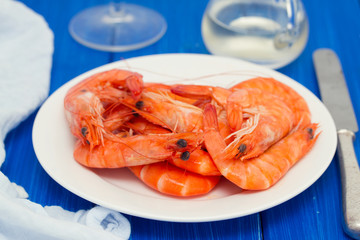 boiled shrimps on white dish on wooden background