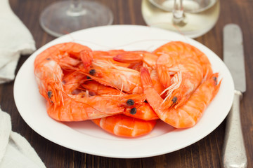 boiled shrimps on white dish on wooden background