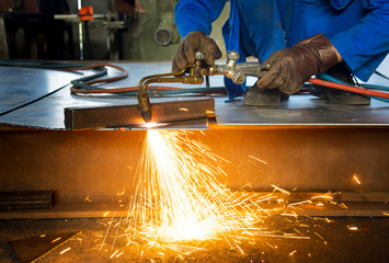 Man cutting metal with a welding cutting torch