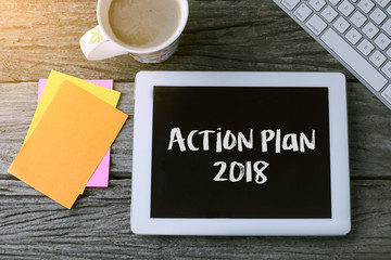 Tablet pc with Action Plan  2018 and a cup of coffee on wooden background.