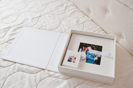 Gorgeous white leather wedding photobooks or photo albums in the box on the white background.