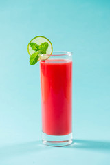 Glass of healthy watermelon juice in summertime on blue background.