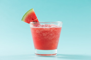 Glass of healthy watermelon juice in summertime on blue background.