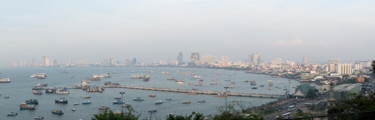 Spectacular sea in front of harbor, Pattaya modern city in smog from the scenic point during sunset time.