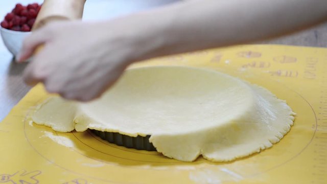 A woman making a crust for a tart. Making tart dough