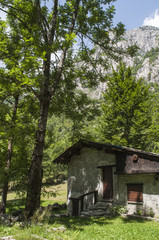 Fototapeta na wymiar Italia: rifugio di montagna nella Val di Mello, una valle verde circondata da montagne di granito e boschi, ribattezzata la Yosemite Valley italiana dagli amanti della natura