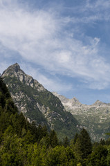 Fototapeta na wymiar Italia: le cime delle montagne della Val di Mello, una valle verde circondata da montagne di granito e boschi, ribattezzata la Yosemite Valley italiana dagli amanti della natura