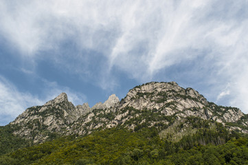 Italia: le cime delle montagne della Val di Mello, una valle verde circondata da montagne di...