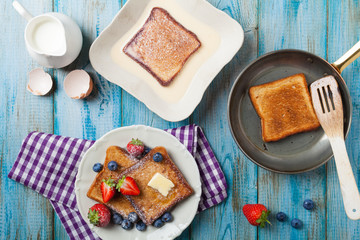 Traditional, delicious, sweet French toast with fruit and butter.