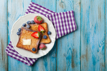 Traditional, delicious, sweet French toast with fruit and butter.