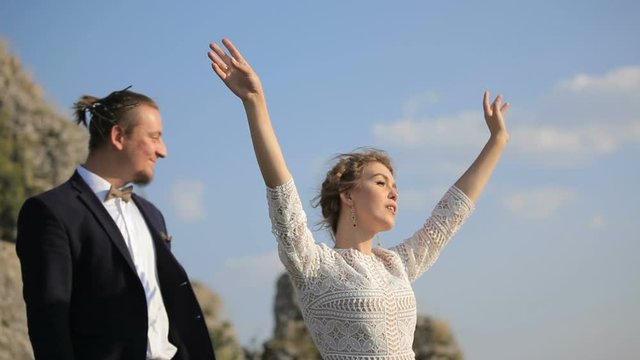 beautiful young couple on the background meadows. loving woman dances before the groom outdoors