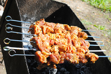 Grilled meat on skewers with onions on grill