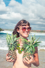 Tropical summer woman with pineapple. Outdoors, ocean, nature. Bali island paradise.
