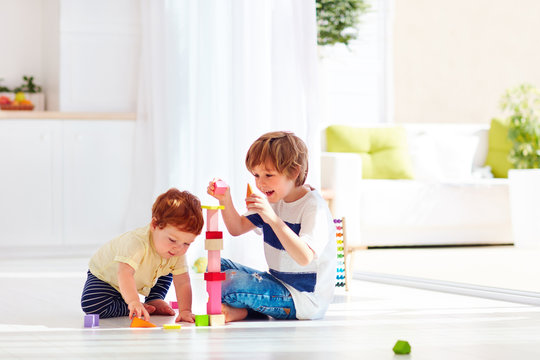 Elder Brother Playing With Junior Baby Boy At Home