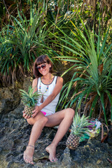 Tropical summer woman with pineapple. Outdoors, ocean, nature. Bali island paradise. Indonesia.