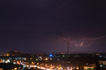 Яркая молния на ночном небе над городом