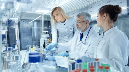 Team of Research Scientists Working With Personal Computer, Analysing Test Trial New Generation...