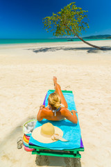 Woman sitting on a bed at the beach