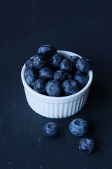 blueberry in a bowl on a black background