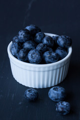 blueberry in a bowl on a black background