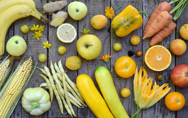 Composition of yellow vegetables and fruits - banana, corn, lemon, plum, apricot, pepper, zucchini, tomato, asparagus beans, ginger. Healthy food. Top view. Flat lay