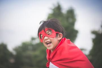 Asian child in in Superhero's costume playing