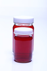 Red Liquid in Glass Bottle white cap