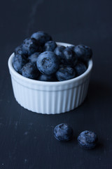 blueberry in a bowl on a black background