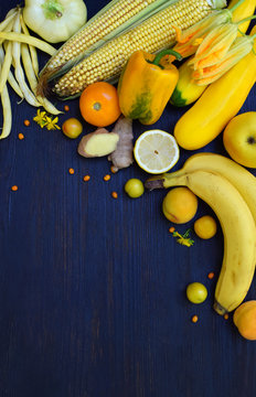 Composition of yellow vegetables and fruits - banana, corn, lemon, plum, apricot, pepper, zucchini, tomato, asparagus beans, ginger. Healthy food. Top view. Flat lay