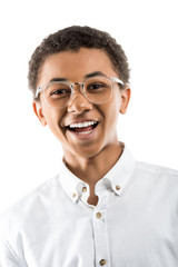 portrait of excited african american teenager in eyeglasses looking at camera isolated on white