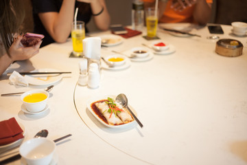 Chinese food on a white table and have people around.