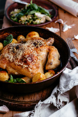 Whole roasted chicken with potatoes on dinner table