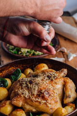 Whole roasted chicken with potatoes on dinner table