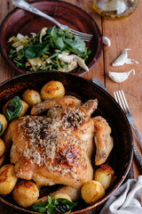 Whole roasted chicken with potatoes on dinner table