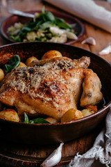 Whole roasted chicken with potatoes on dinner table