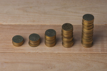 Business Concept : Gold coin stacked on wooden background.