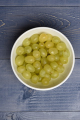 Bowl of white grapes on vintage surface
