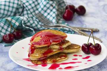 Homemade pancakes with cherry syrup.
