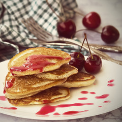 Homemade pancakes with cherry syrup.