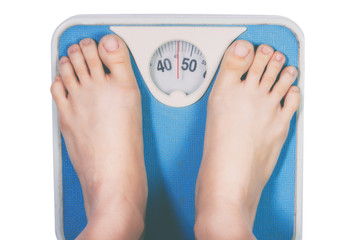 Bare female feet standing on bathroom scale