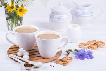 Medicinal plant chicory, Diet drink chicory in a cup with milk for breakfast on a white table.