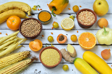 Composition of yellow vegetables, beans and fruits - banana, corn, lemon, plum, apricot, pepper,...