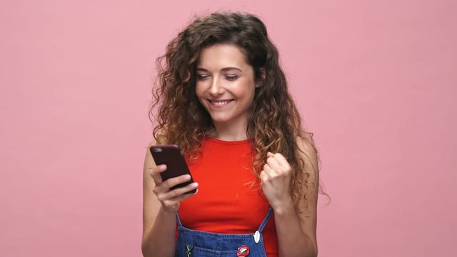 Young happy caucasian woman chatting isolated over pink background