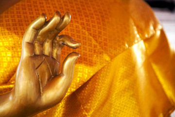 Golden Buddha statue hand gesture close-up with copy space. Asian symbolic ok mudra, thumb and index fingers joined