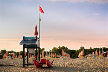 Lifeguard tower on a beach with rescue boat.