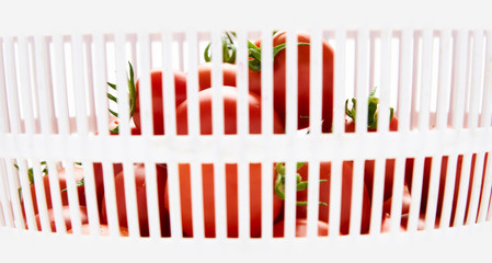 Fresh ripe red tomatoes in a colander isolated on a white background