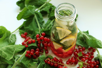 Drink of mint, lemon and red currant in bottle of glass with straw. between in Ingredients