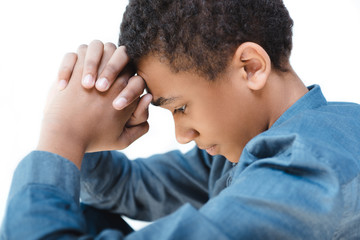 side view of pensive african american teenage boy with hands in lock